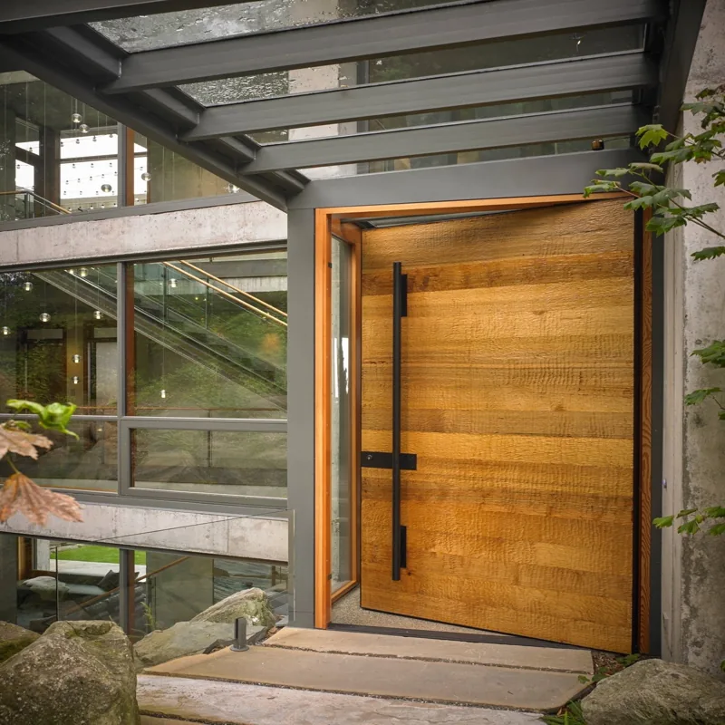 Modern oversized pivot wood door with black handle